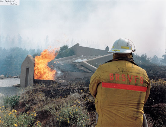 A firefighter works to contain blazes as they descend on Bill and Deann’s home on Sugarloaf Mountain.
